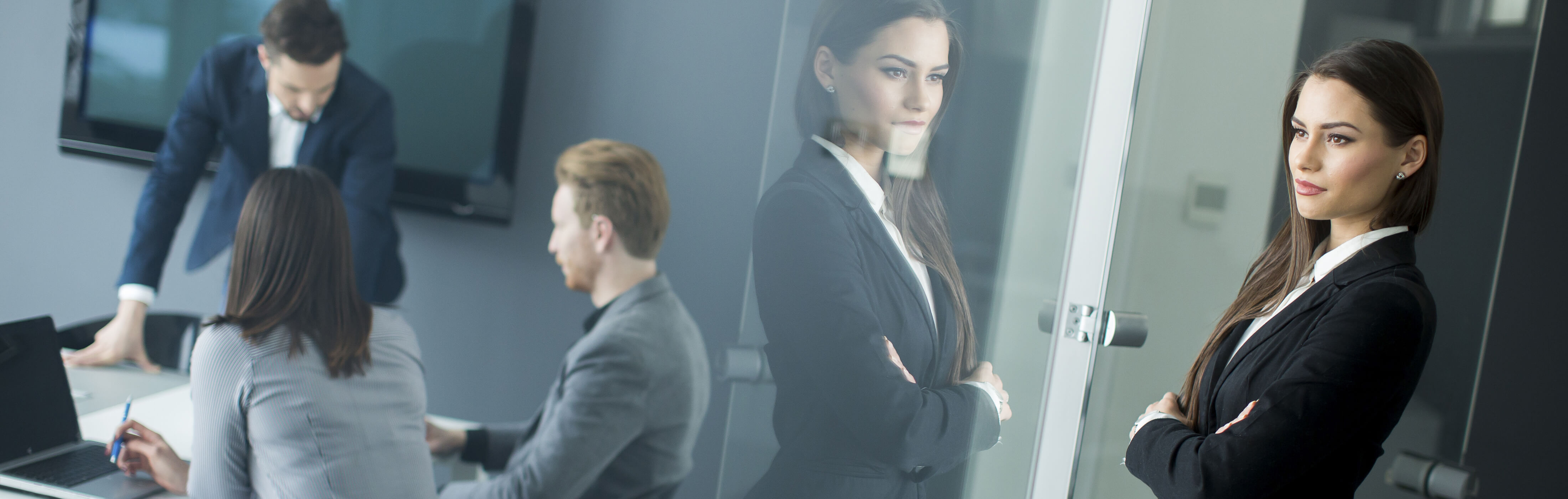 Attractive female manager watching her team through glass office wall, banner at the top of InnoScale Hosting's Server Management Packages page